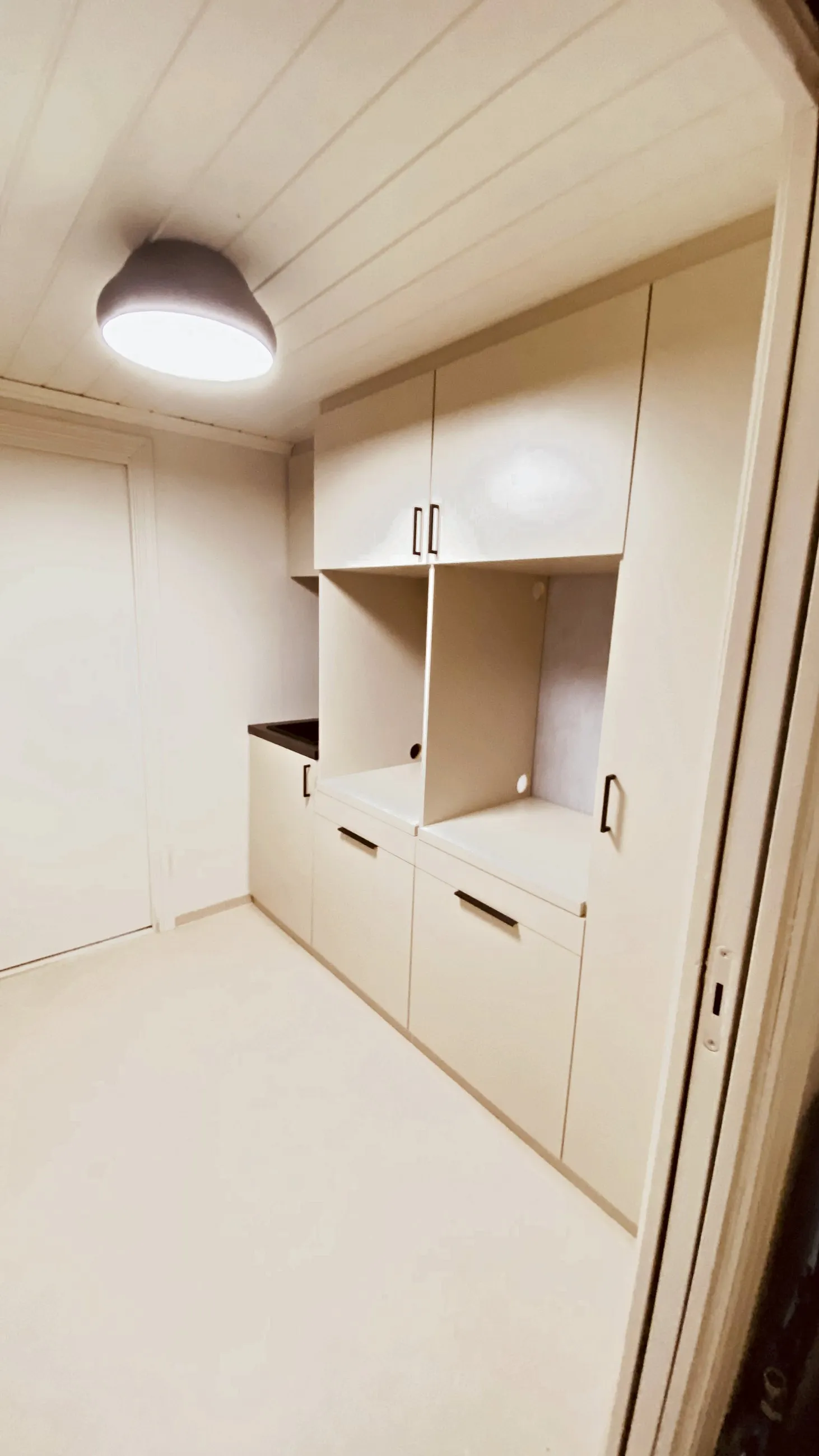 Vaskerom i beige med steinbenk, overskap og åpen nisje over benken